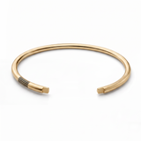 Gold vermeil open cuff with parallel black groove details near one end.