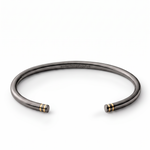 Black rhodium open cuff with twin gold-tone line details at each end and engraved somethingaboutus logo.